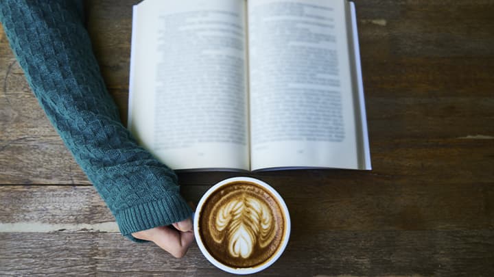 Book and cup of coffee on the table