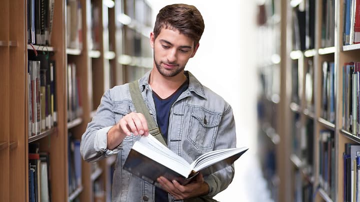 Guy with a book in the library